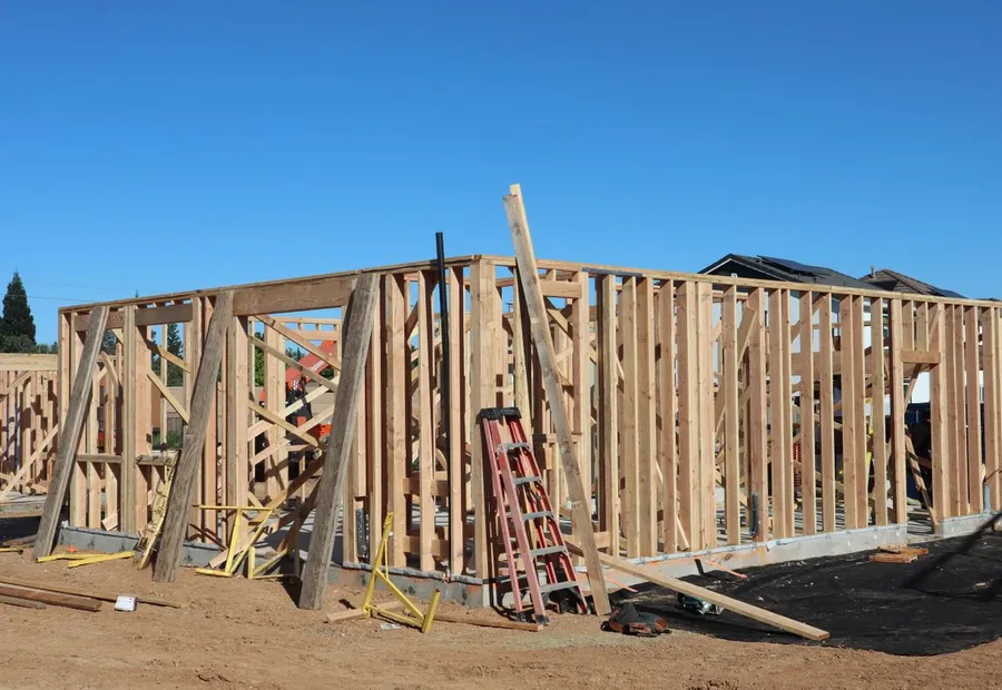 Bare stud walls with diagonal bracing and a stepladder inside an unsheathed house frame